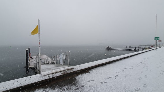 Einzelne Fußspuren sind auf dem verschneiten Fußweg zu sehen. © NDR Foto: Carsten Salzwedel