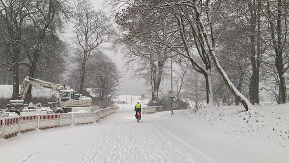 Ein Fahrradfahrer bahnt sich seinen Weg durch eine verschneite Baustelle © dpa Foto: Birgitta von Gyldenfeld