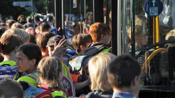 Zahlreiche Schüler steigen in einen Bus ein. © IMAGO / Funke Foto Services 