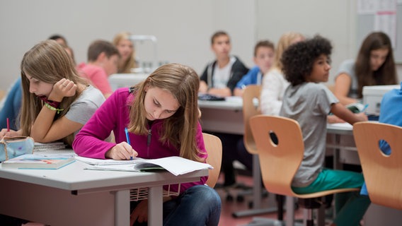 Schülerinnen und Schüler sitzen in einem Unterrichtsraum und arbeiten konzentriert. © picture alliance / photothek Foto: Michael Gottschalk