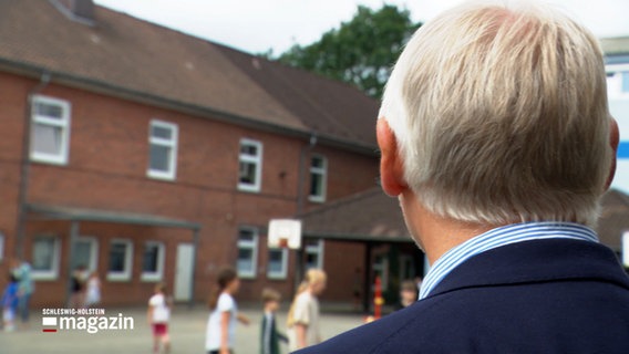 Ein Mann blickt auf einen Schulhof. © NDR 