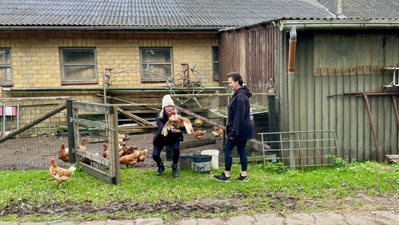 Zwei Frauen blicken auf ein Huhn Schutzhof in Schlichting. © NDR Foto: Sophie Apelt