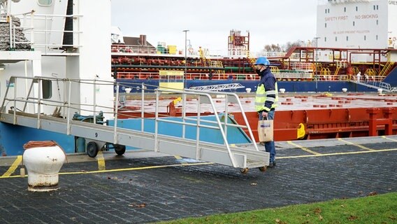 Ein Mitglied der Seemannsmission verteilen Geschenke an die Frachtschiff-Crews. © NDR Foto: Lisa Pandelaki