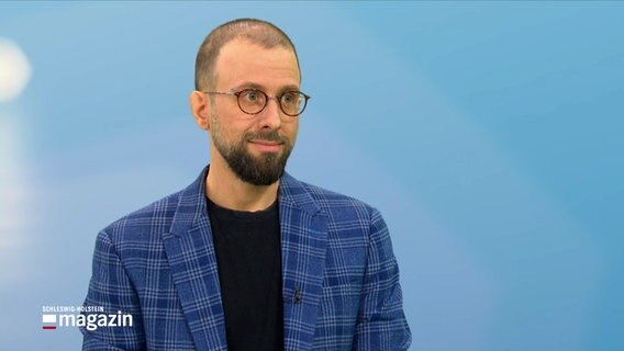 Ein Mann steht im Studio des Schleswig-Holstein Magazins, es ist Dr. Christian Hoffarth
. Er ist Historiker an der Universität Kiel. © NDR Foto: NDR Screenshots