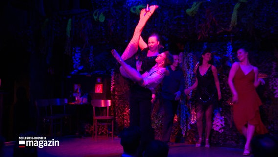 Während einer Tanzaufführung wird eine Frau von einem Tanzpartner in die Luft gehoben © NDR Foto: NDR Screenshot