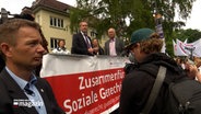 Schleswig-Holsteins Ministerpräsident Daniel Günther (CDU) hält auf einer Kundgebung vor Demonstranten eine Rede © NDR Foto: NDR Screenshot