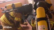 Drei Feuerwehrleute bei einer Übung © NDR Foto: NDR Screenshot