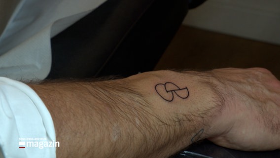 Ein Tattoo auf dem Unterarm einer Person, ein Kreis und zwei Halbkreise, es soll ein Zeichen für Organspender sein. Der Kreis steht dabei für ein O, die Halbkreise für ein D, daraus ergeben sich die Initialen für "Organ Donor" © NDR Foto: NDR Screenshot