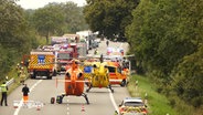 Nach einem Verkehrsunfall stehen mehrere Einsatzfahrzeuge und Rettungshubschrauber auf einer Landstraße © NDR Foto: NDR Screenshot