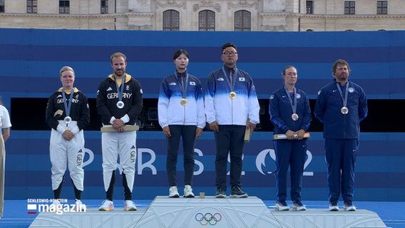 Mehrere Athleten stehen bei Olympia auf dem Podium © NDR Foto: NDR Screenshot