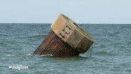 Im Wasser steht ein Dalben, dieser ist knapp um 45 Grad gekippt © NDR Foto: NDR Screenshot