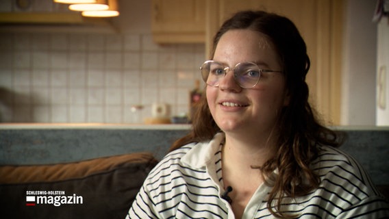 Eine Frau gibt, auf einem Sofa sitzend, ein Interview © NDR Foto: NDR Screenshot