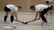 Ein Hockeytrainer erklärt einer Hockespielerin einen Spielzug © NDR Foto: NDR Screenshot