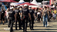 Eine Gruppe von Polizisten läuft Streife auf einem Volksfest © NDR Foto: NDR Screenshot