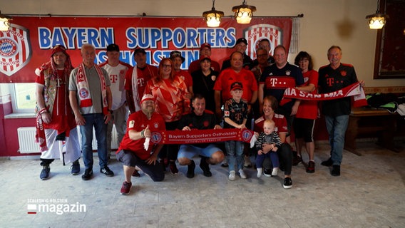 Fans des Fußballverein "FC Bayern München" posieren für ein Gruppenfoto © NDR Foto: NDR Screenshot