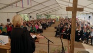 Der Blick von einem Altar in einem Zelt in dem eine Andacht zu einem Erntedankfest gehalten wird © NDR Foto: NDR Screenshot