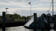 In einem Hafen liegt ein gekentertes Hausboot © NDR Foto: NDR Screenshot