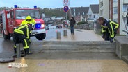 Feuerwehrleute errichten eine Blockade gegen eine Sturmflut © NDR Foto: NDR Screenshot