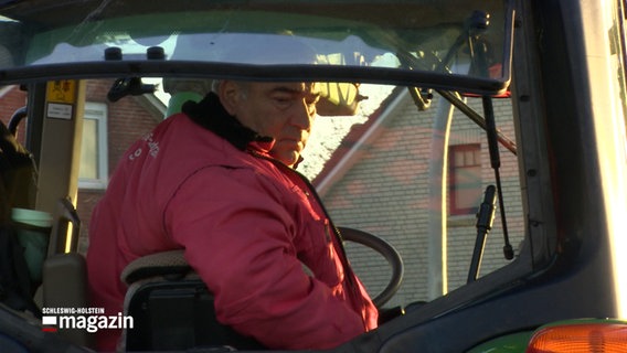 Ein Mann fährt mit einem Traktor rückwärts © NDR Foto: NDR Screenshot