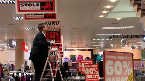 Werbetafeln in einem Kaufhaus weisen auf den bevorstehenden Winterschlussverkauf hin © NDR Foto: NDR Screenshot