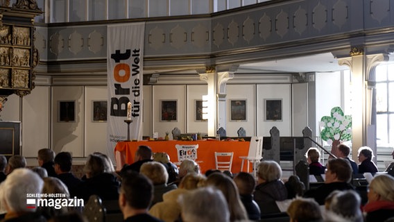 In einer Kirche ist ein Stand für "Brot für die Welt" aufgebaut © NDR Foto: NDR Screenshot