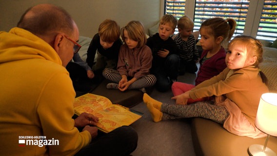 Ein Mann liest einer Kindergartengruppe aus einem buch vor © NDR Foto: NDR Screenshot