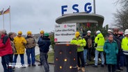 Beschäftigte der FSG demonstrieren vor dem Haupteingang zum Werftgelände © NDR Foto: NDR Screenshot