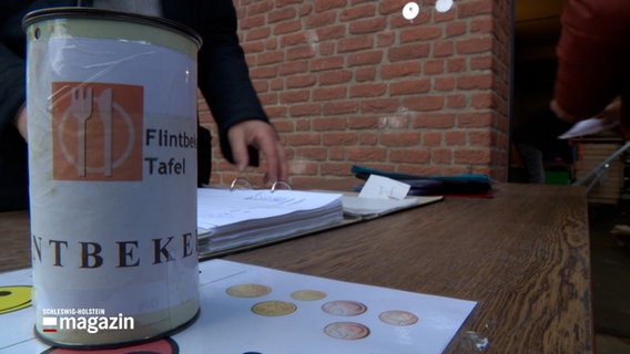 Eine Spendendose der Tafel Flintbek steht auf einem Tisch © NDR Foto: NDR Screenshot