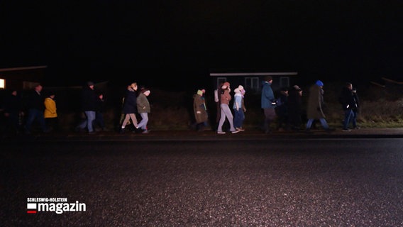 Menschen wandern in der Nacht über eien Fußweg als Teil einer Nachtwanderung © NDR Foto: NDR Screenshot