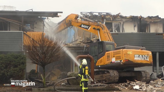 Ein Bagger arbeitet an einem Haus, dass durch einen Brand beschädigt wurde. © NDR Foto: NDR Screenshot