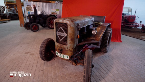 EIn alter Ackerschlepper steht vor einem roten Vorhang in einem museum © NDR Foto: NDR Screenshot