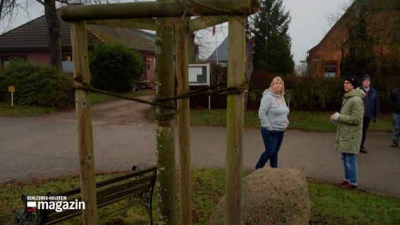 Zwei Personen sind in einem Gespräch und betrachten dabei einen Baum © NDR Foto: NDR Screenshot