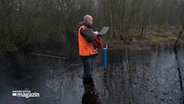 Ein Mann steht mit einem Laptop in einem Moor und macht Untersuchungen © NDR Foto: NDR Screenshot