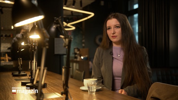 Eine Frau gibt in einem Café ein Interview © NDR Foto: NDR Screenshot