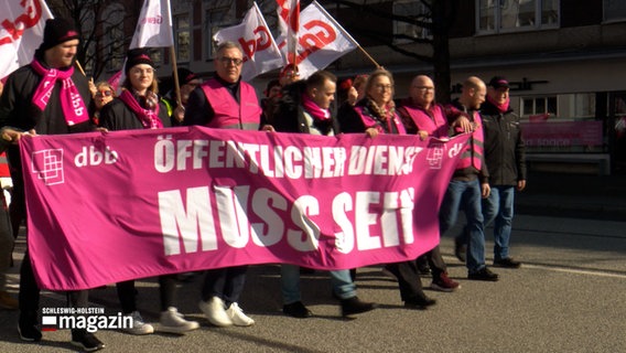 Demonstranten mit einem Banner, auf diesem Steht: "Öffentlicher Dienst muss sein" © NDR Foto: NDR Screenshot