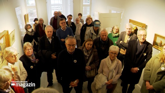 Mehrere Menschen stehen bei einer Führung in einem Museum gedrängt zusammen © NDR Foto: NDR Screenshot