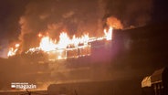 Die Fassade eines Hotels steht in Flammen © NDR Foto: NDR Screenshot