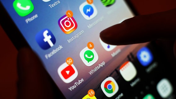 Ein Daumen schwebt über einem Smartphone-Bildschirm mit vielen Social Media Apps. © picture alliance / empics Foto: Yui Mok