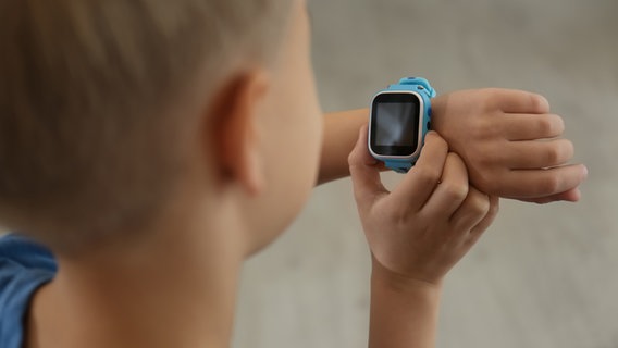 Ein Junge trägt eine blaue Smartwatch am Handgelenk. © IMAGO / Pond5 Images 