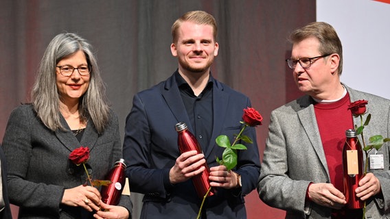 Nina Scheer (l-r), Tim Klüssendorf und Ralf Stegner, halten rote Rosen in Händen nachdem sie auf die ersten drei Listenplätze der SPD Schleswig-Holstein für die Bundestagswahl 2025 gewählt worden. © picture alliance/dpa Foto: Felix Müschen