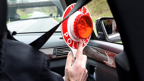 Ermittler der Bundespolizei bereitet in der Nähe von Flensburg mit seiner Haltekelle die Kontrolle eines verdächtigen Fahrzeuges vor. © DPA Foto: Carsten Rehder