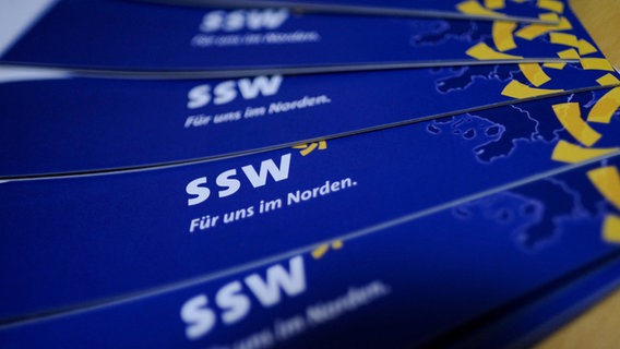 Mehrere Prospekte mit dem Logo der Partei SSW liegen aus. © dpa Foto: Axel Heimken