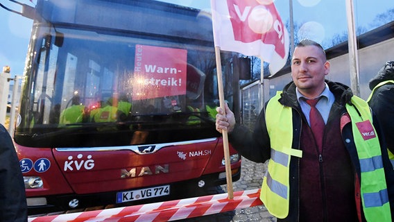 Ein streikender Busfahrer steht vor einem leeren Bus. © dpa-Bildfunk Foto: Carsten Rehder/dpa