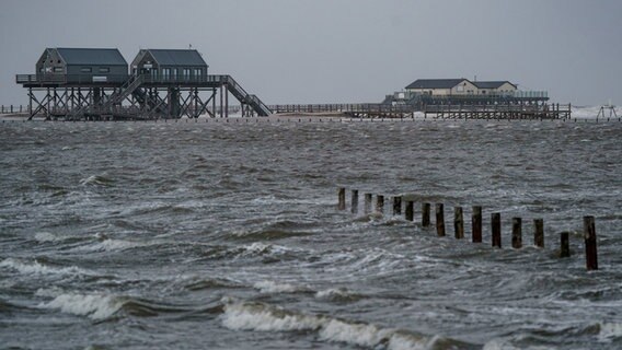 St. Peter-Ording: Wellen brechen an den Pfahlbauten am vollständig überspülten Strand © dpa-Bildfunk Foto: Axel Heimken