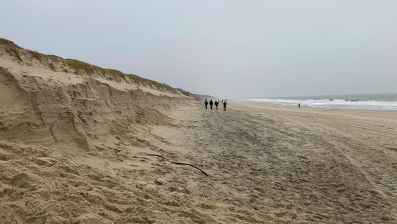 Menschen spazieren enetlang vom Sylter Strand. © NDR Foto: Simone Mischke