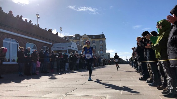 Zahlreiche Zuschauer unterstützen Sportler während des Syltlaufs 2019 bei strahlender Sonne. © NDR Foto: Rudolf Dautwiz