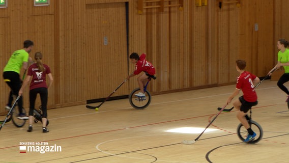 In einer Turnhalle wird Einrad Hockey gespielt. © NDR 