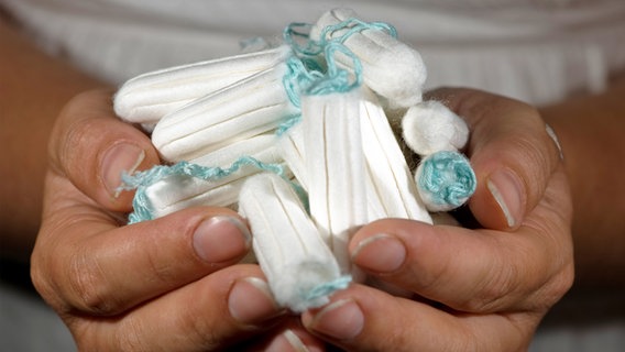 Eine Frau hält Tampons in ihren Händen. © picture alliance / dpa Themendienst Foto: Franziska Gabbert