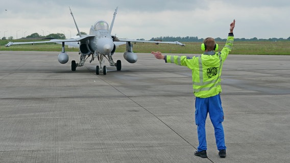 Ein F-18 Kampfjet wird vom Bodenpersonal eingewiesen. © NDR Foto: Peer-Axel Kroeske
