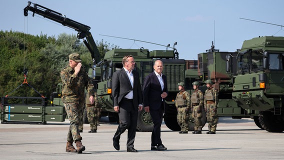 Todendorf: Bundeskanzler Olaf Scholz (SPD, r-l), Boris Pistorius (SPD), Bundesminister der Verteidigung, und Ingo Gerhartz (l), Inspekteur der Luftwaffe, nehmen an der feierlichen Indienststellung des Luftverteidigungssystems IRIS- T SLM in der Kaserne Todendorf teil. © dpa Foto: Christian Charisius